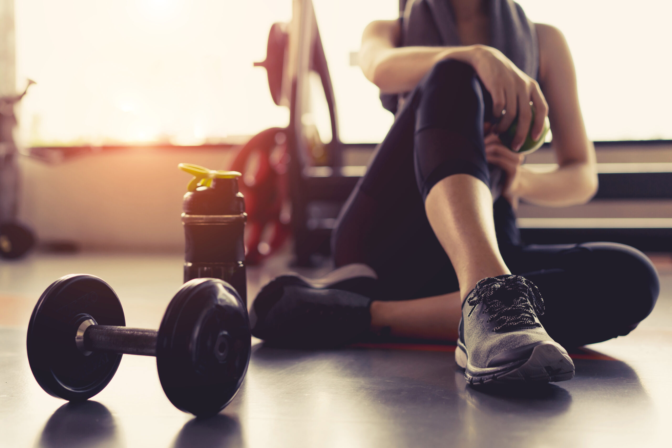 Woman exercise workout in gym fitness breaking relax holding app